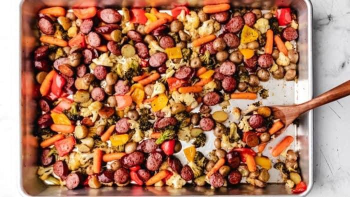 a photo of sheet pan sausage and veggies on a big pan