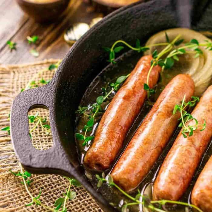 a photo of three pieces smoked sausage brats on a casserole