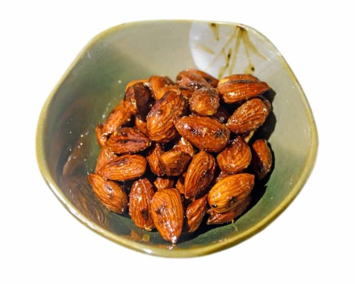 Roasted almonds with wasabi, maple syrup, soy sauce in a Asian bowl (Isolated in white background)