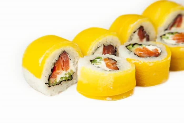 Sushi roll with takuan and smoked salmon on a white plate, classic Japanese sushi