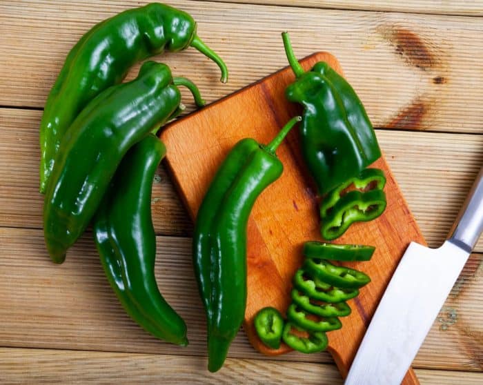 Closeup of fresh bell pepper with chopped slices on wooden surface