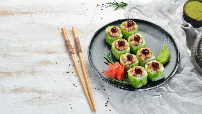 Green Sushi rolls - with eel fish and green Tobiko caviar. Pieces of delicious sushi