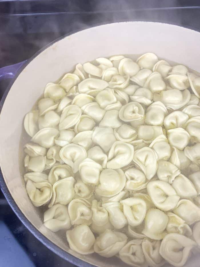Once the tortellini are cooked al dente, drain them and rinse under cool water to stop the cooking process by cooling the pasta down.
