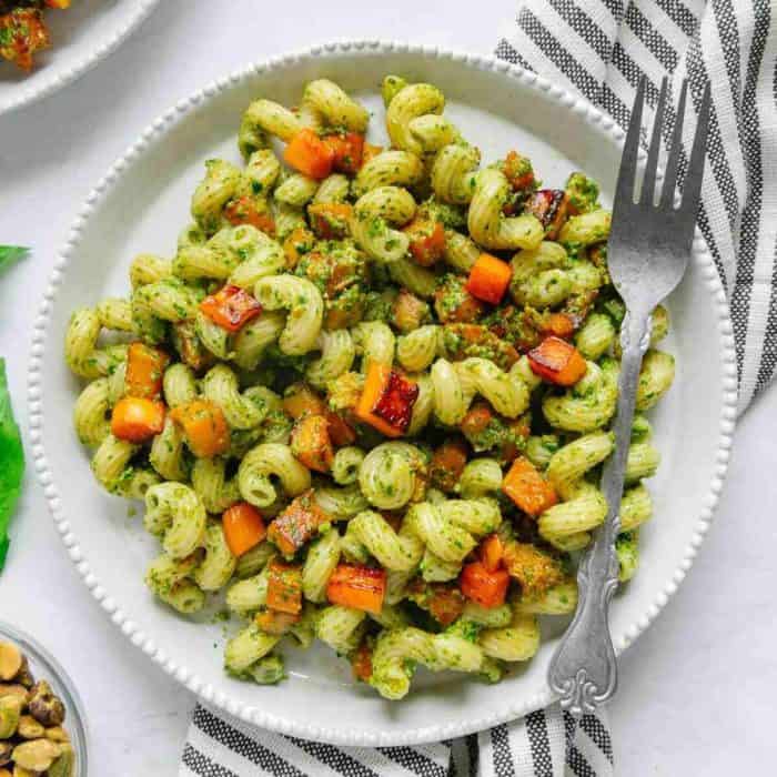 a plate of Pesto Pasta with Maple Roasted Butternut Squash and a fork on the side 