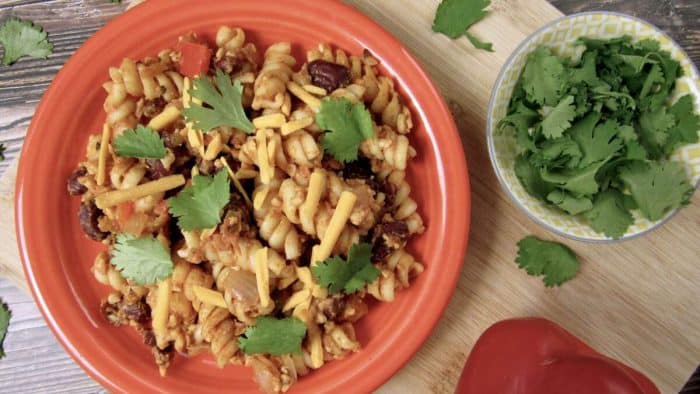 a photo of vegan Taco Pasta on a round red plate