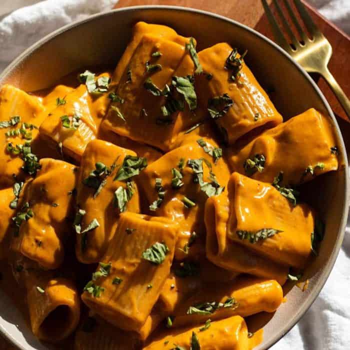 a plate of Vegan High-Protein Sweet Potato Harissa Pasta with a fork on the side