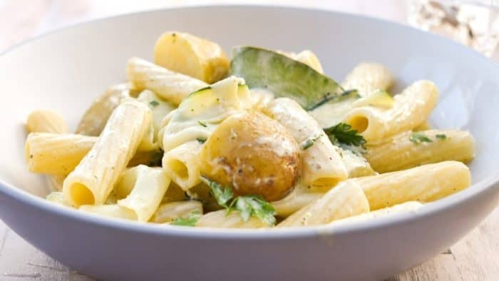 a plate of vegan Creamy Courgette Pasta With Potatoes on a table