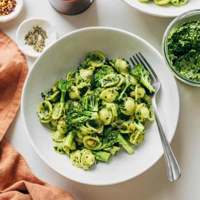a photo of a plate of kale pesto pasta with a fork on the side
