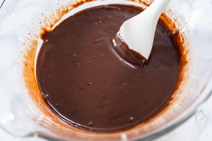 Preparing chocolate ganache in a glass mixing bowl.