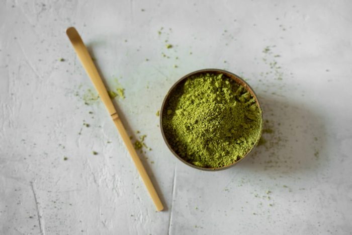 Matcha tea in a brown cup on a gray background