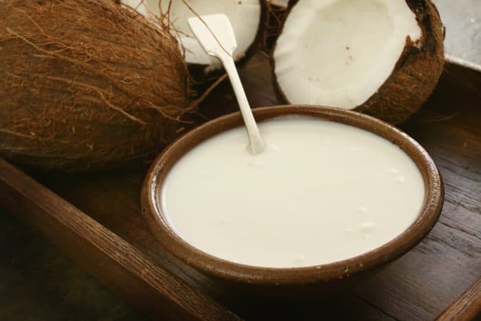 Fresh coconut with milk on a wooden table