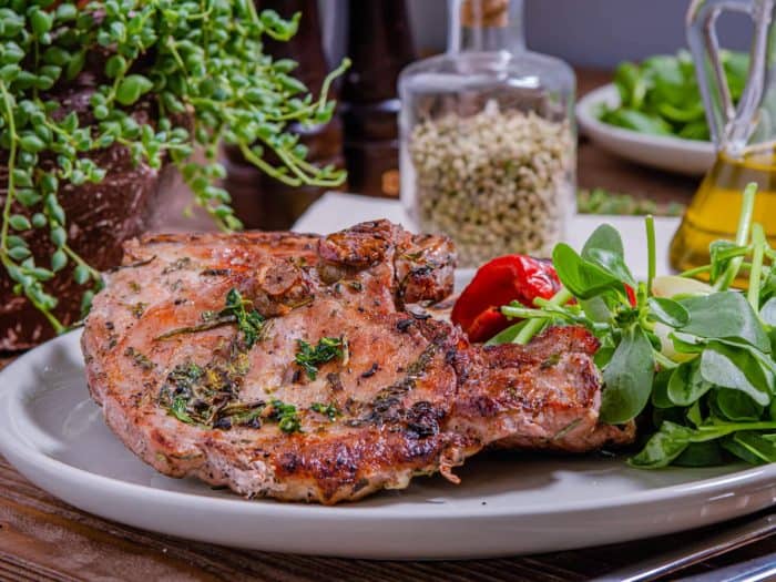 These grilled pork chops are not your average dinner; they're a symphony of basil, thyme, and rosemary, married with the unmistakable char of a grill. 