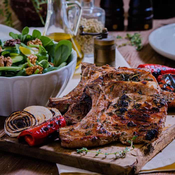 These grilled pork chops are not your average dinner; they're a symphony of basil, thyme, and rosemary, married with the unmistakable char of a grill. 