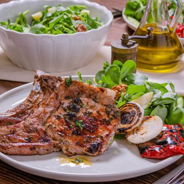These grilled pork chops are not your average dinner; they're a symphony of basil, thyme, and rosemary, married with the unmistakable char of a grill.