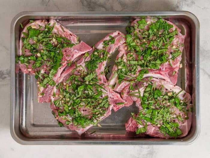 Combine the kosher salt, basil, rosemary, thyme, garlic, carbon salt, and black pepper in a bowl. Rub this fragrant mixture onto each pork chop, ensuring a thorough coat.