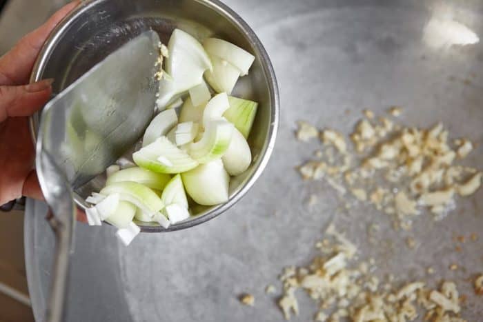 Heat 2 tablespoons of olive oil in a stock pot over medium-high heat. Sauté the onion and garlic until soft and translucent, which should take about 4 to 5 minutes.
