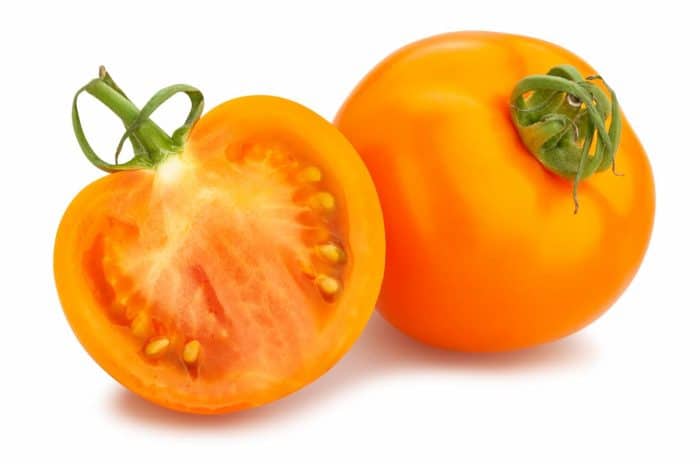 a slice of orange tomato on a white isolated white background