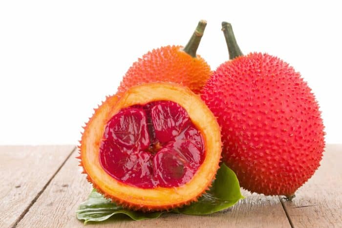 gac fruit placed on a wooden table on a white background