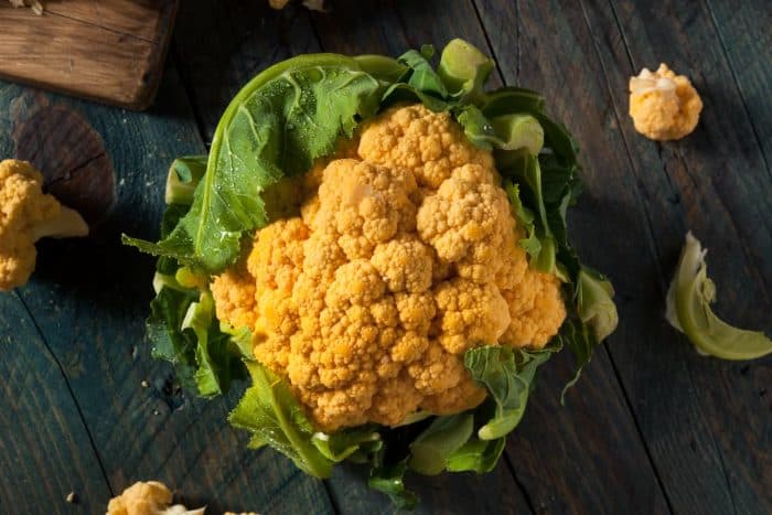 Raw Organic Orange Cauliflower on a wooden table