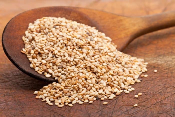 a wooden spoon full of sesame seeds