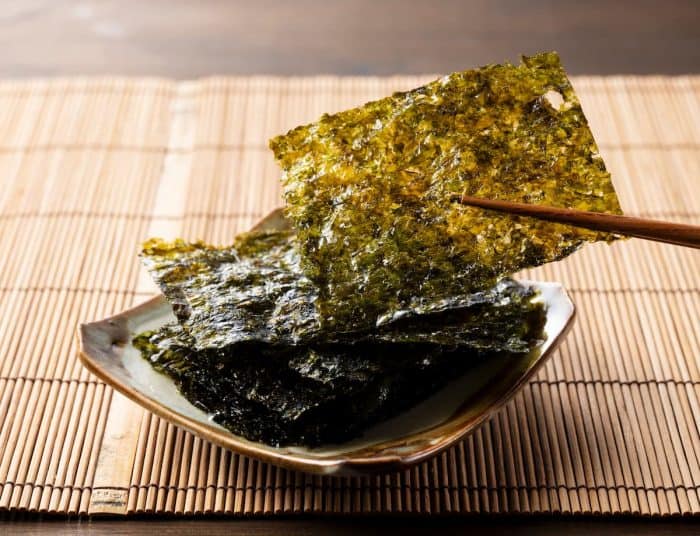 Korean seaweed arranged on a plate on a wooden table.
