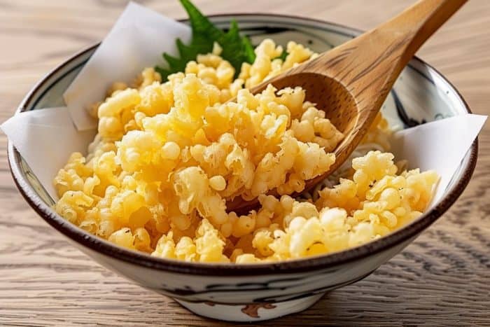 a realistic image of tempura bits, Light and airy, tempura bits, also known as tenkasu, introduce a unique crunch and absorb the flavors of the ramen broth, adding depth to the dish.