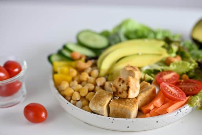 Close-up image, Healthy salad mixed with grilled tofu. chickpea, tomatoes, avocado, cucumber, green salad vegetables. Vegan food and plant based recipe concept