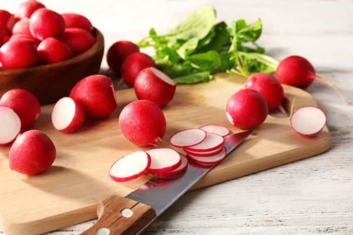 Fresh sliced radishes on cutting board close up