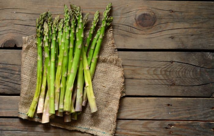 a bunch of asparagus spears placed on top of a kitchen towel on a wooden table