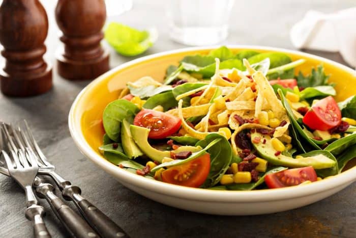 Mexican salad with tortilla strips, corn and avocado