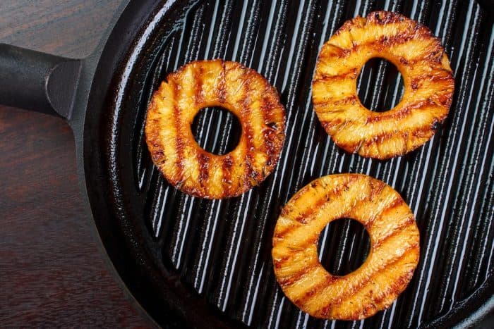 black grilling pan with 3 slices of pineapple