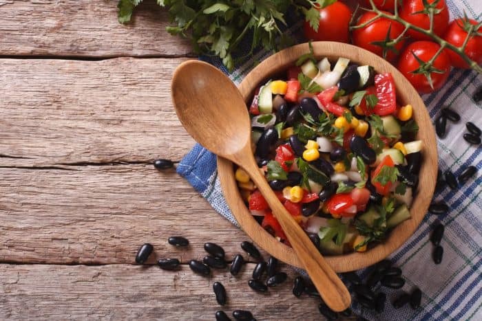 Mexican vegetable salad in a wooden bowl, close-up
