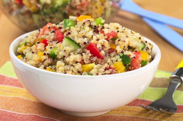 a white bowl ful of vegetable salad with quinoa