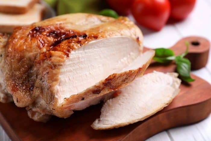 Delicious sliced turkey fillet on a wooden chopping board