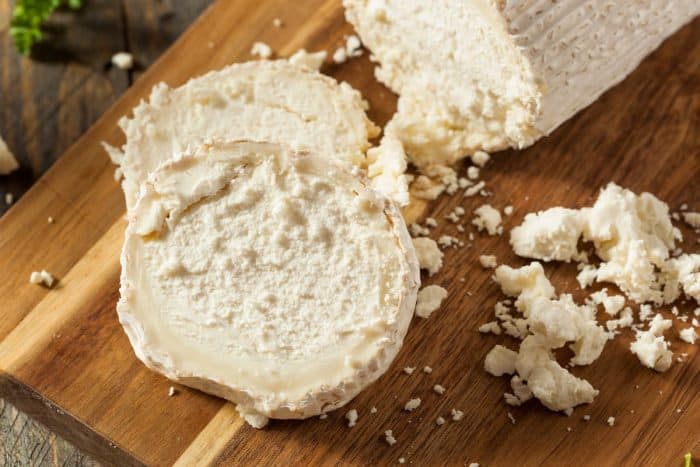 Raw White Organic Goat Cheese on a wooden chopping board