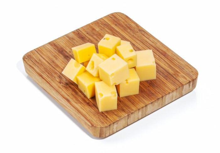 sharp cheddar Cheese isolated on white background and served on a wooden chopping board