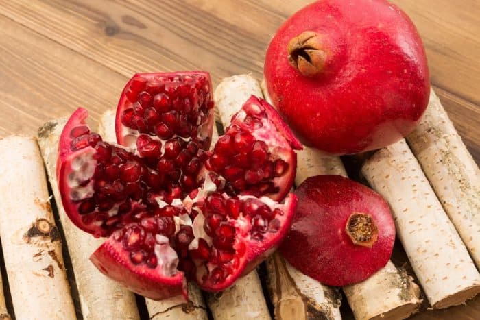 fresh Pomegranate sections on a wooden countertop