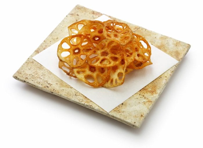 a plate of Homemade crispy lotus root chips isolated on white background