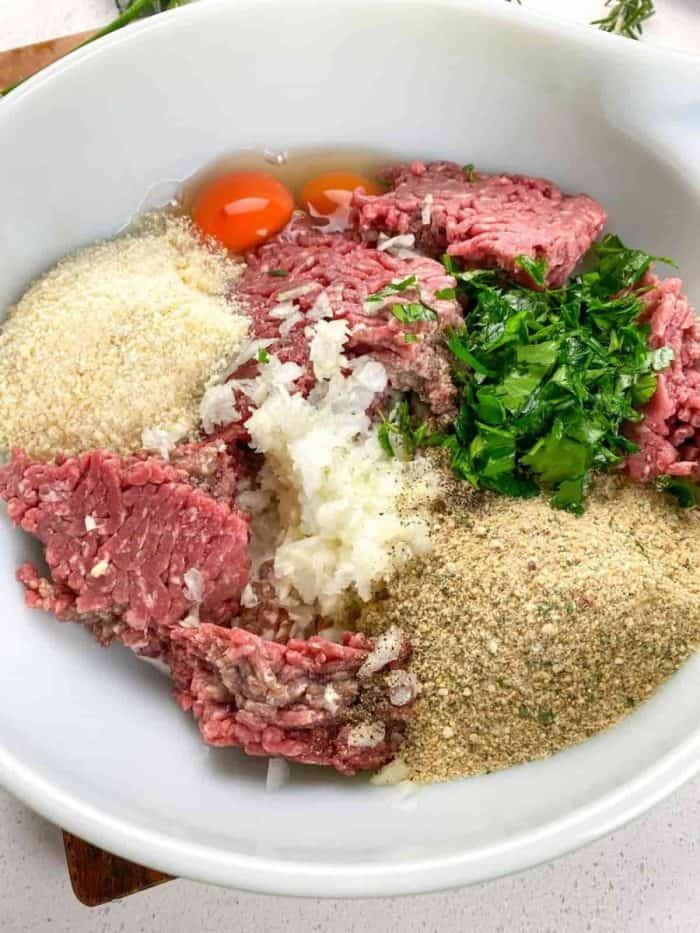 In a large mixing bowl, combine beef, pork, onion, garlic, breadcrumbs, parmesan cheese, eggs, and whole milk. Add salt and pepper to taste. 