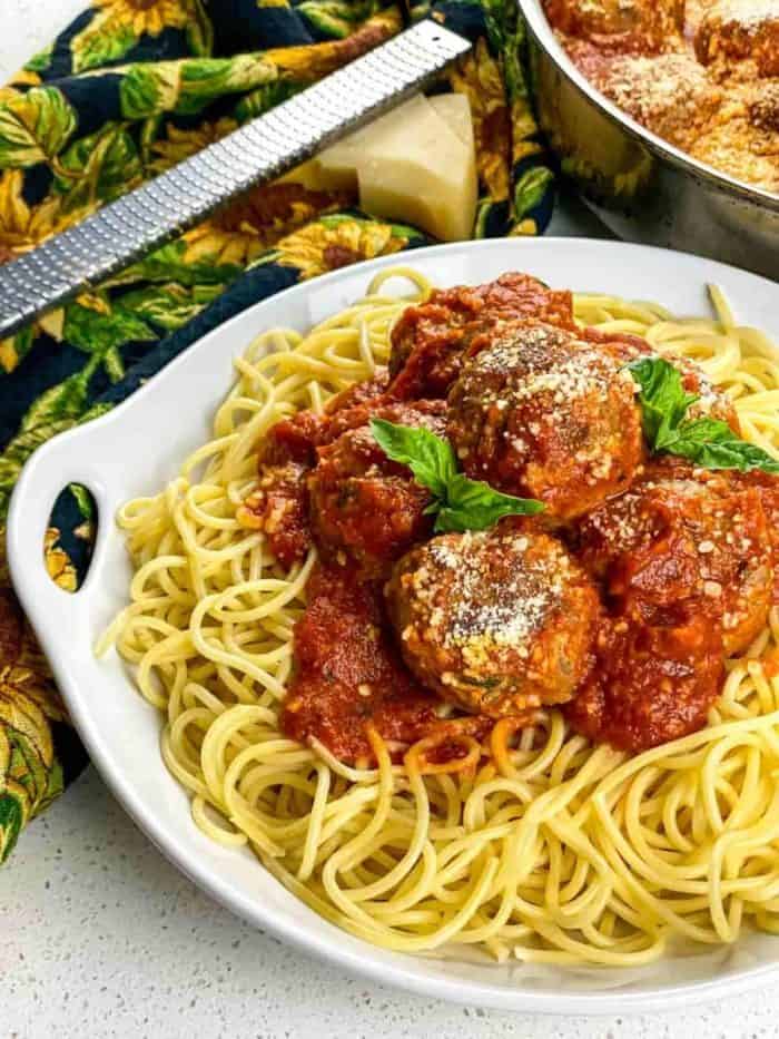 Pile the cooked spaghetti onto a serving platter, top with the saucy meatballs, and garnish with parmesan and fresh basil for a picture-perfect meal. Enjoy!