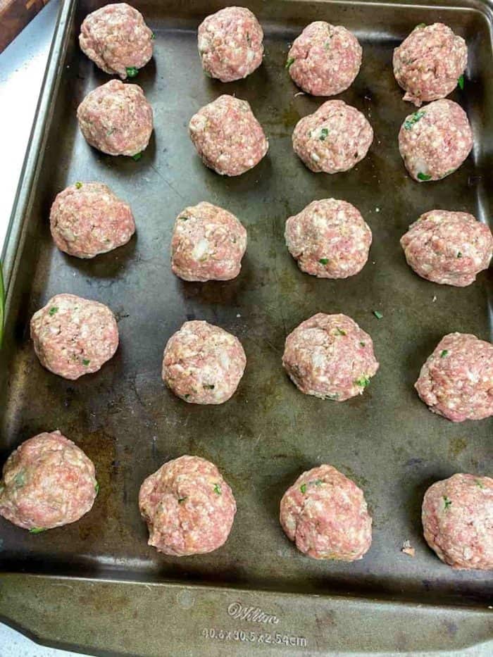Using an ice cream scoop, form the mixture into balls and arrange them on two rimmed baking sheets, ensuring they're not crowded to allow even cooking.