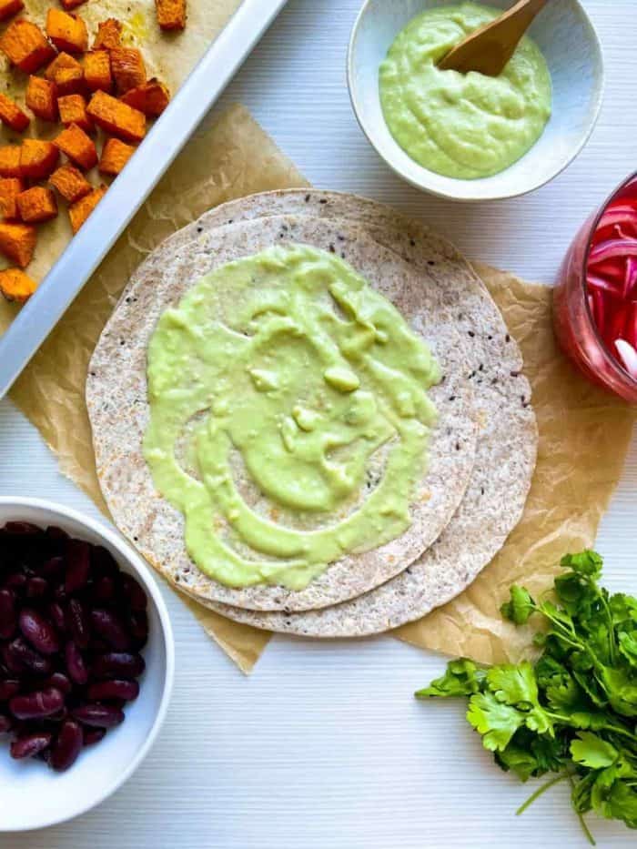 In a blender, combine avocado, sour cream, garlic, and lime juice. Blend until smooth and creamy. 