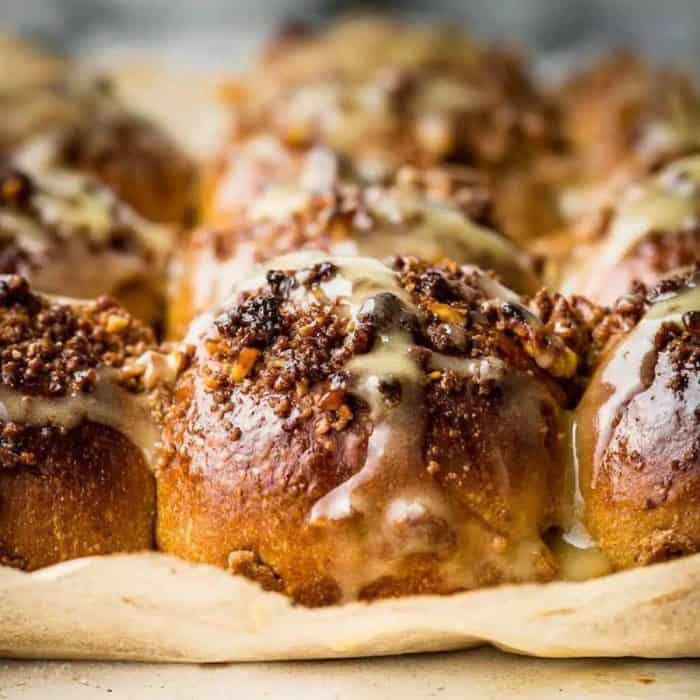 These walnut streusel hot cross buns boast a soft, spiced dough filled with sweet carrots and are topped with a crunchy walnut streusel and vegan cream cheese drizzle.