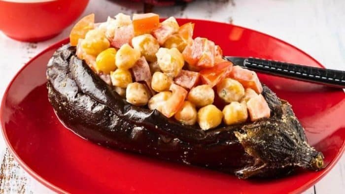 The eggplants are hollowed out and filled with a hearty mixture of chickpeas, tomatoes, and aromatic herbs, then baked to perfection for a satisfying plant-based meal.