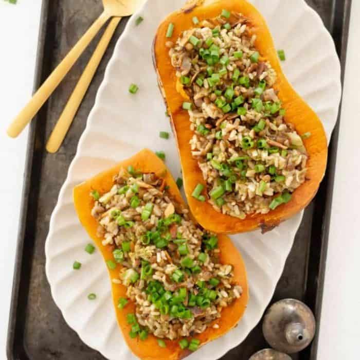 This vegan stuffed butternut squash recipe epitomizes spring with its vibrant filling of quinoa, cranberries, and pecans.