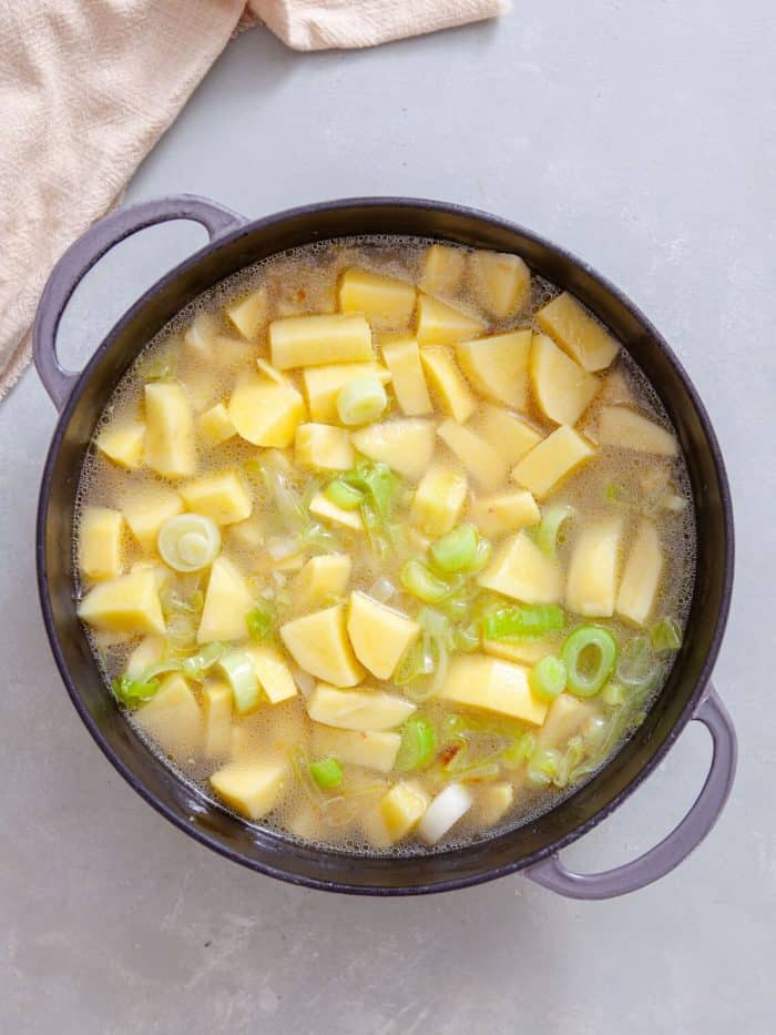 Add the chicken broth and potatoes. Increase the heat to high and bring to a rapid boil, then reduce the heat to just below medium. Cover the skillet loosely with a lid. 