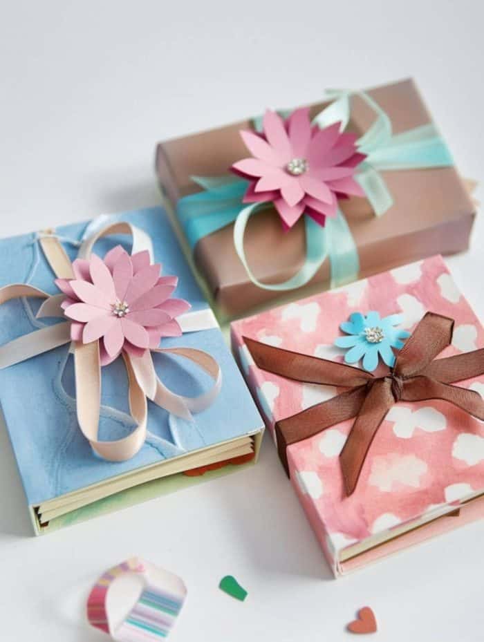 Perfect for capturing treasured moments, this Mother's Day craft idea involves creating a DIY paper photo album with paper flowers and fun ribbons in soft pastel colors.
