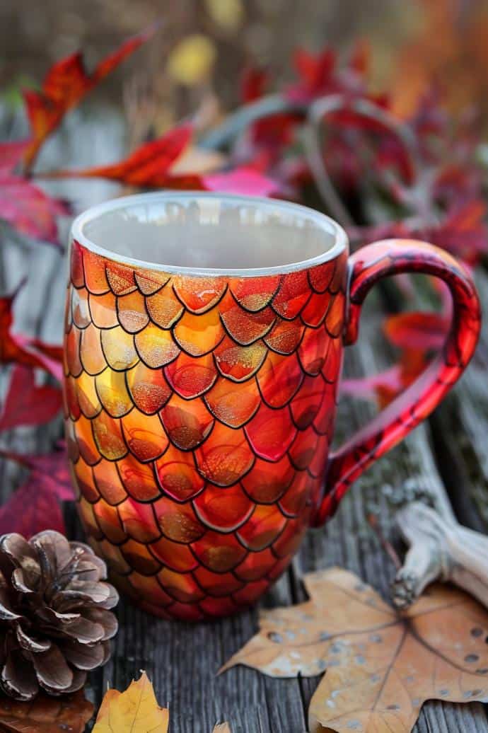 A pattern of fiery dragon scales wraps around the mug, each scale shaded with vibrant reds, oranges, and yellows to mimic the intensity of dragonfire.