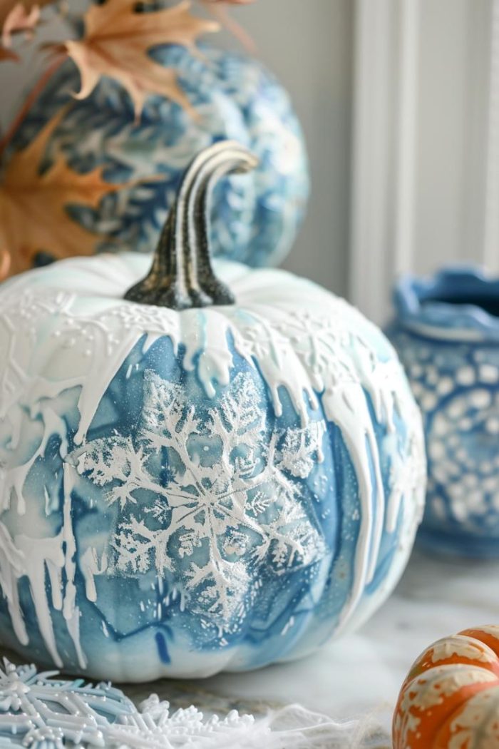 The intricate beauty of snowflakes and the shimmering allure of icicles are captured in white and icy blue paints on these winter-themed pumpkins. 