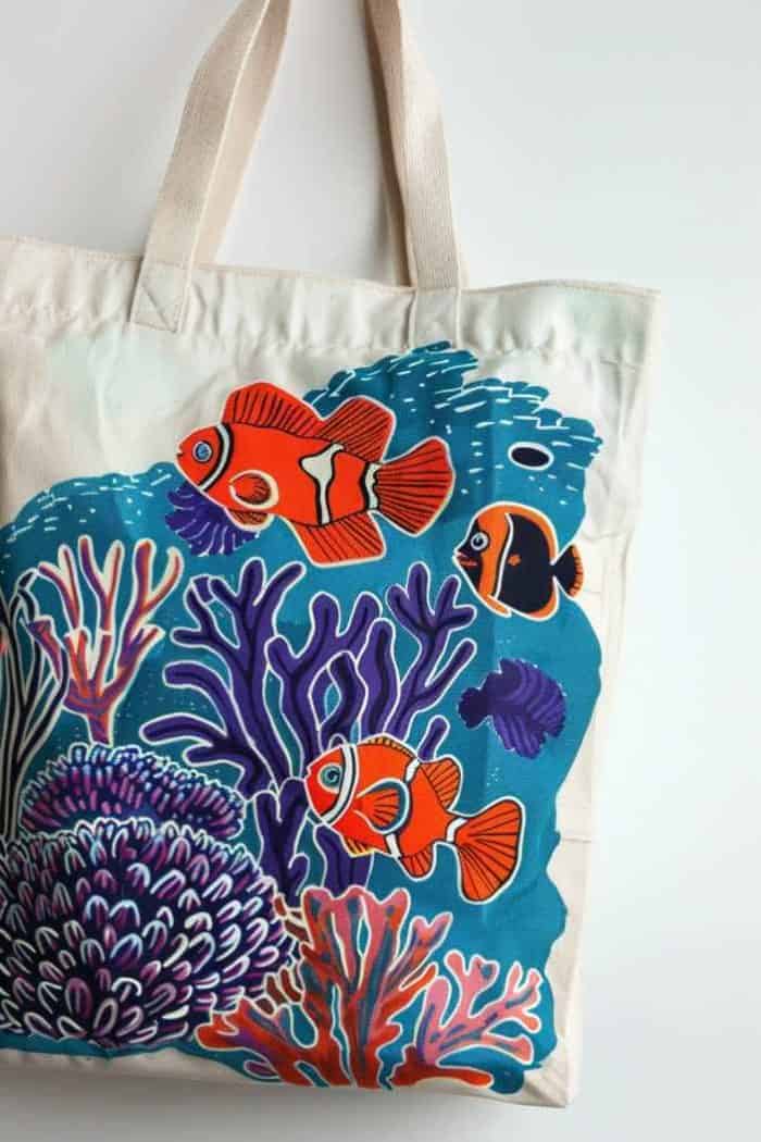 Dive into the depths of the sea with this tote, which showcases fish swimming amongst the corals.